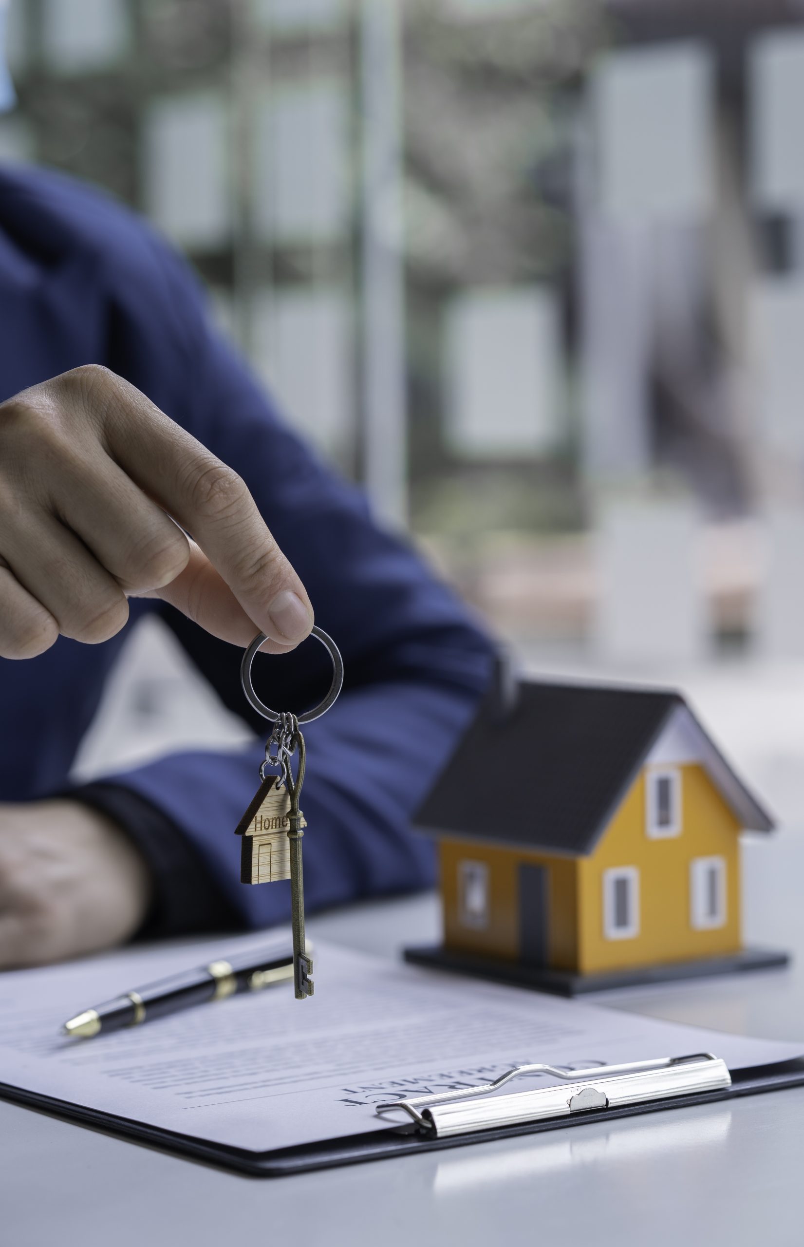 Real estate agent passing keys to his client, Hand of real estate agent passes the key to new homeowners in office with buyer house concept.